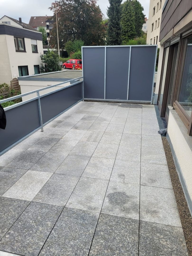 Ein Balkon mit grauen Platten